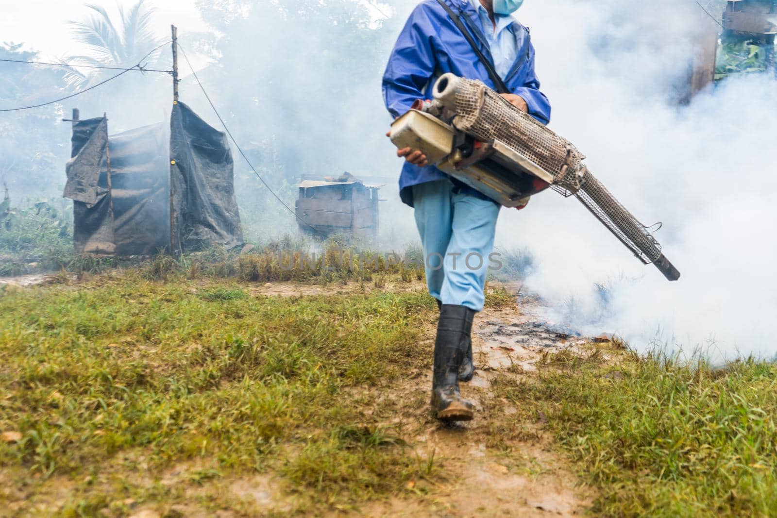 Unrecognizable man using a machine to fumigate and exterminate dengue-transmitting mosquitoes in El Rama Nicaragua