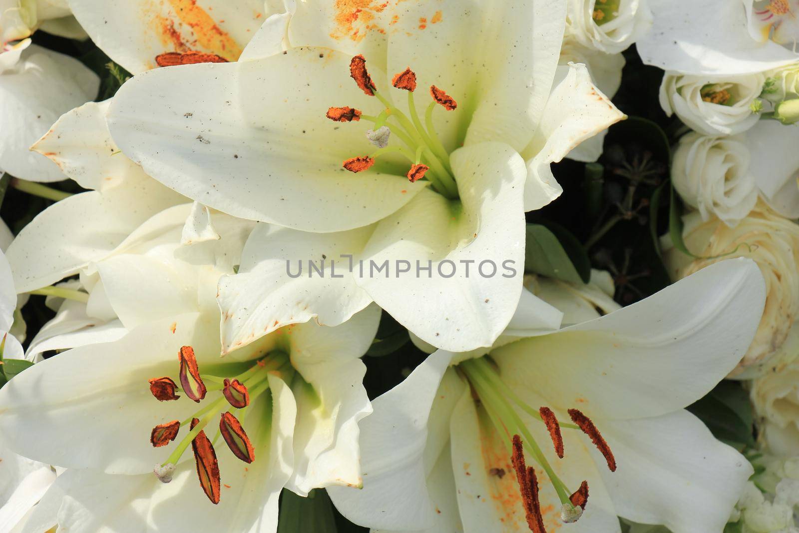 Big white lilies in a floral wedding decoration by studioportosabbia
