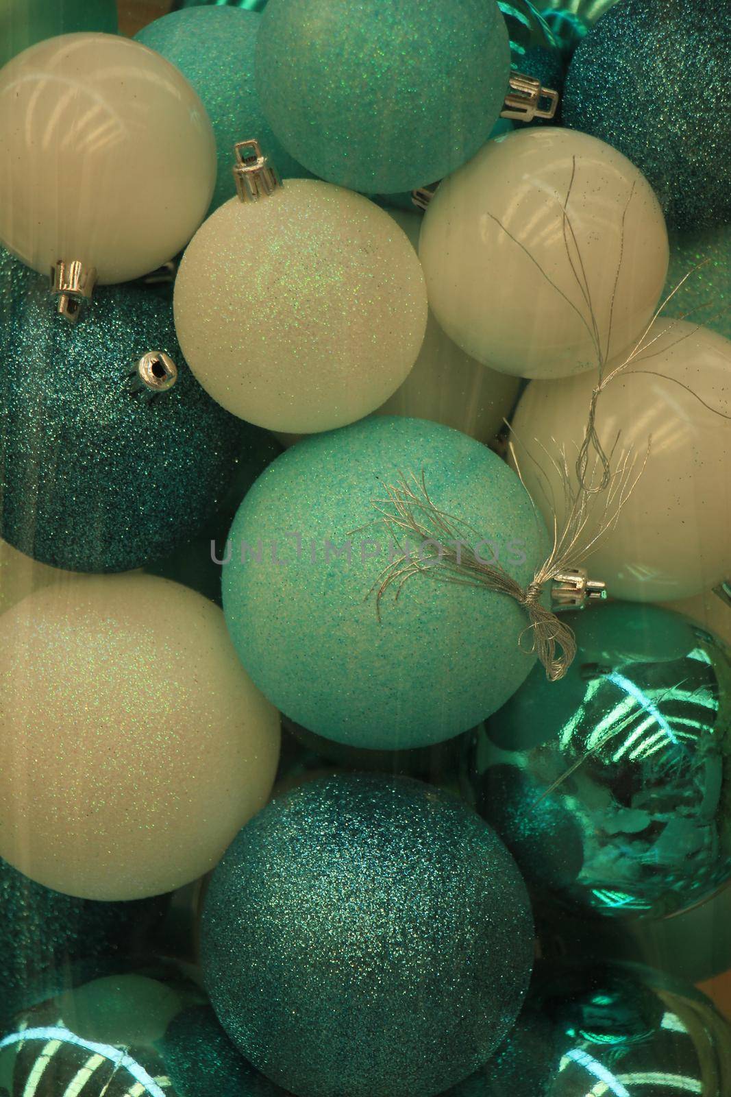 Christmas ornaments in teal and pastel blue colors in a christmas retail shop by studioportosabbia
