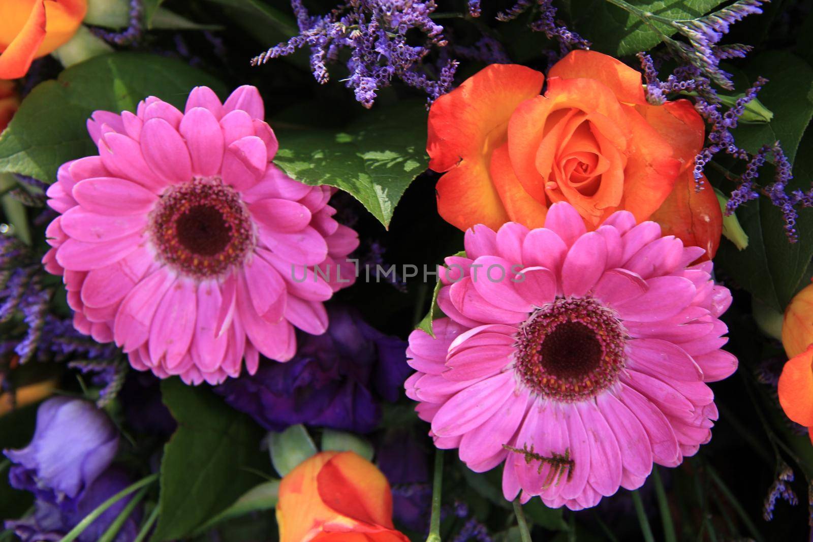 Mixed flower arrangement: various flowers in purple and orange for a wedding by studioportosabbia