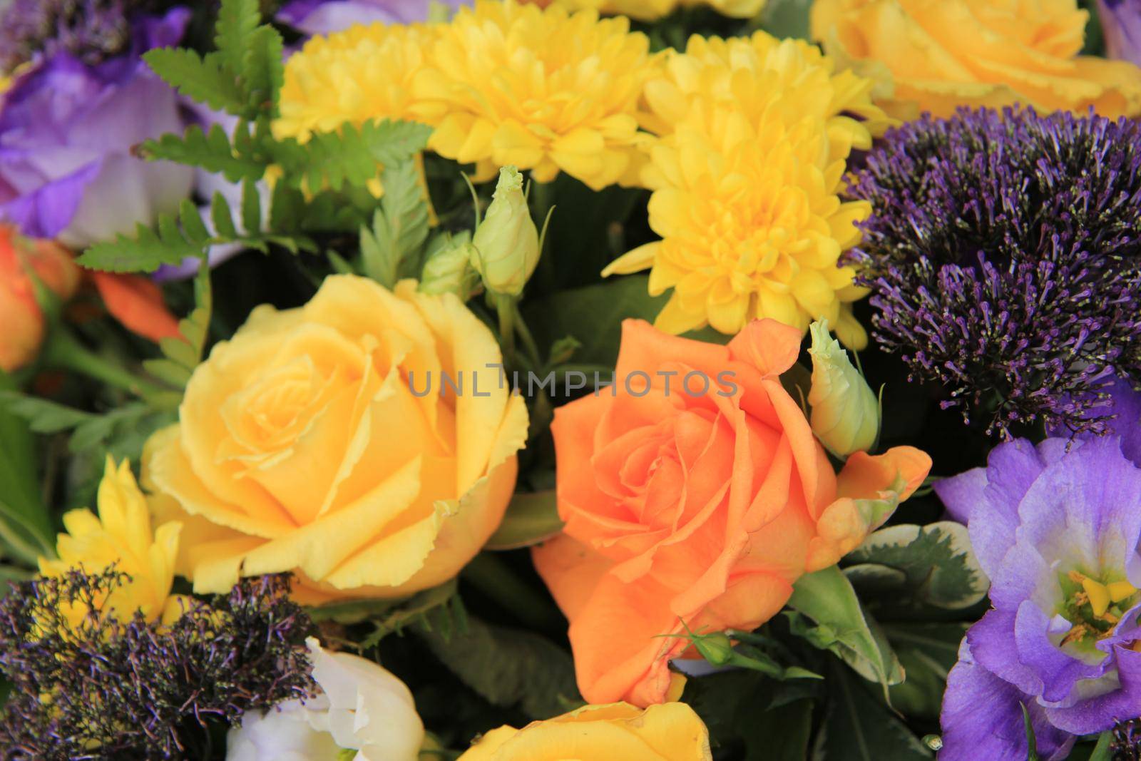 Mixed flower arrangement: various flowers in yellow, orange and purple for a wedding