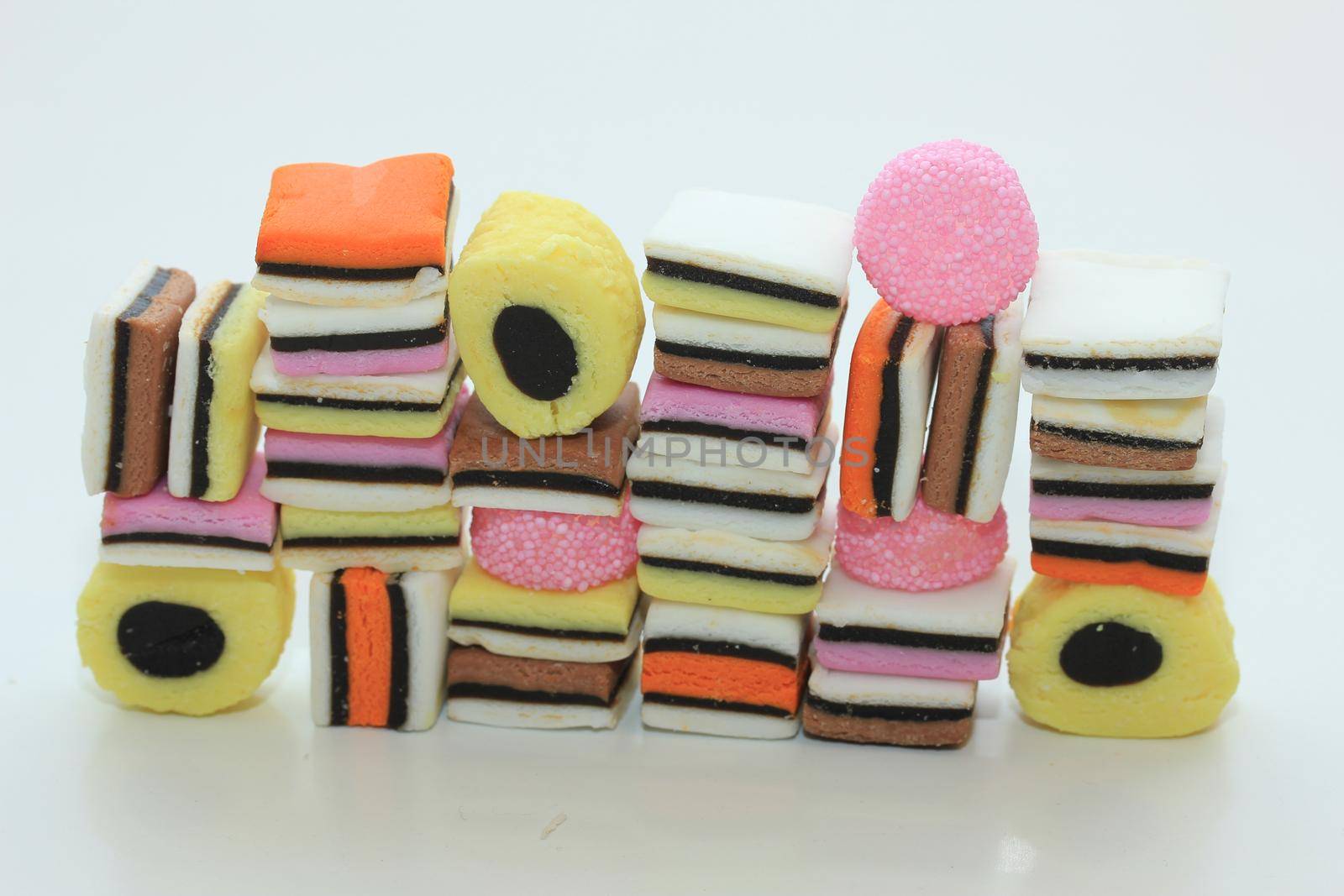 Stacked liquorice allsorts in different shapes, colors and sizes