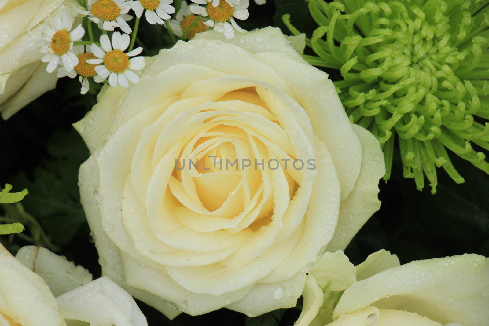 White wedding roses in a floral wedding decoration with some green