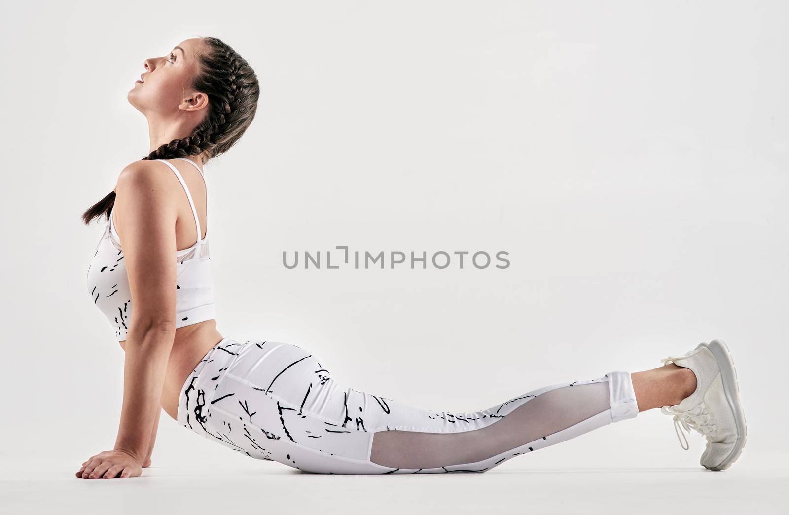You dream, you plan, you reach. Studio shot of a sporty young woman exercising against a white background. by YuriArcurs