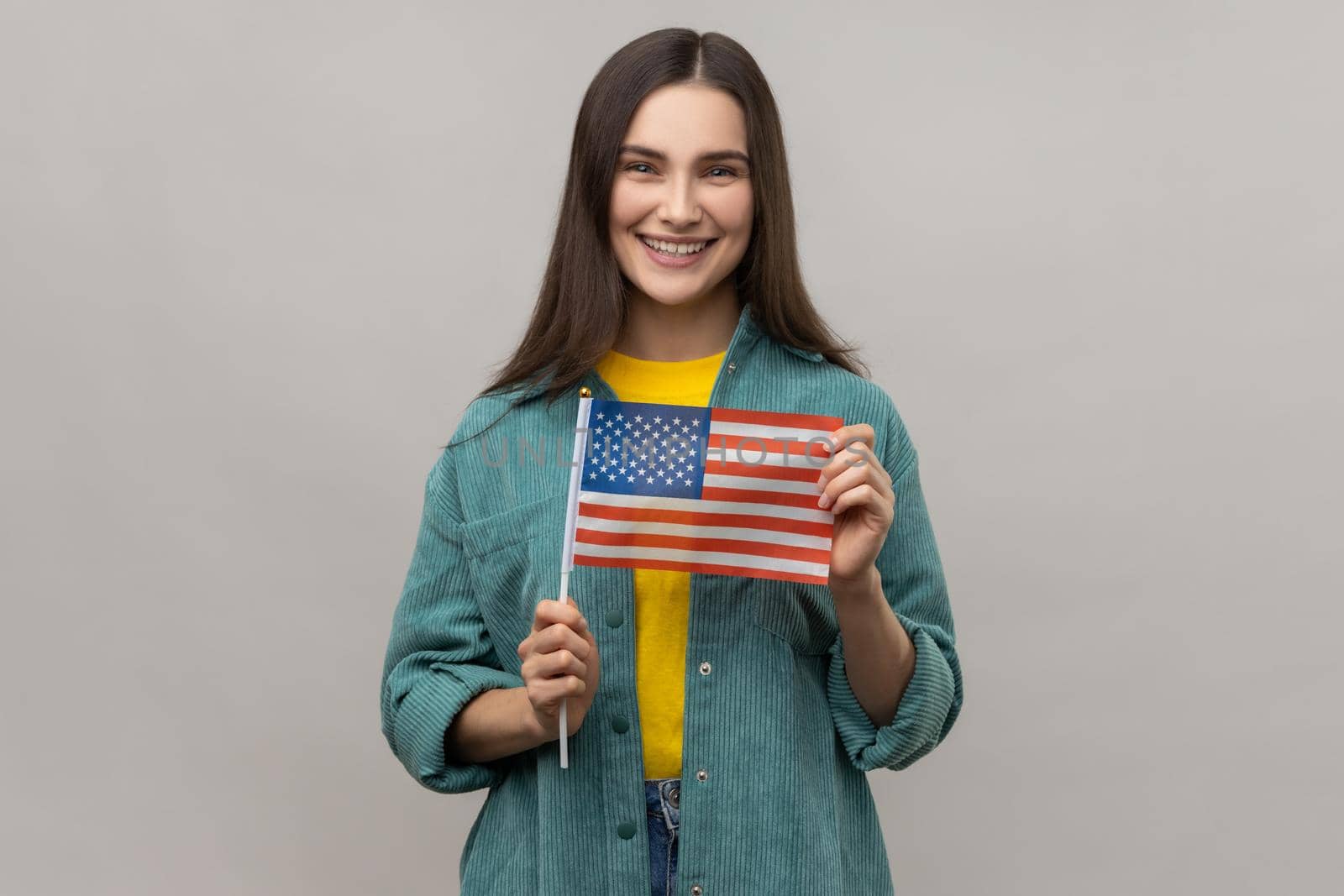 Young happy satisfied woman standing and holding american flag, celebrating national holiday. by Khosro1