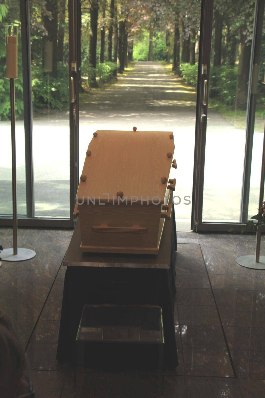 Plain light wooden coffin in a crematorium by studioportosabbia