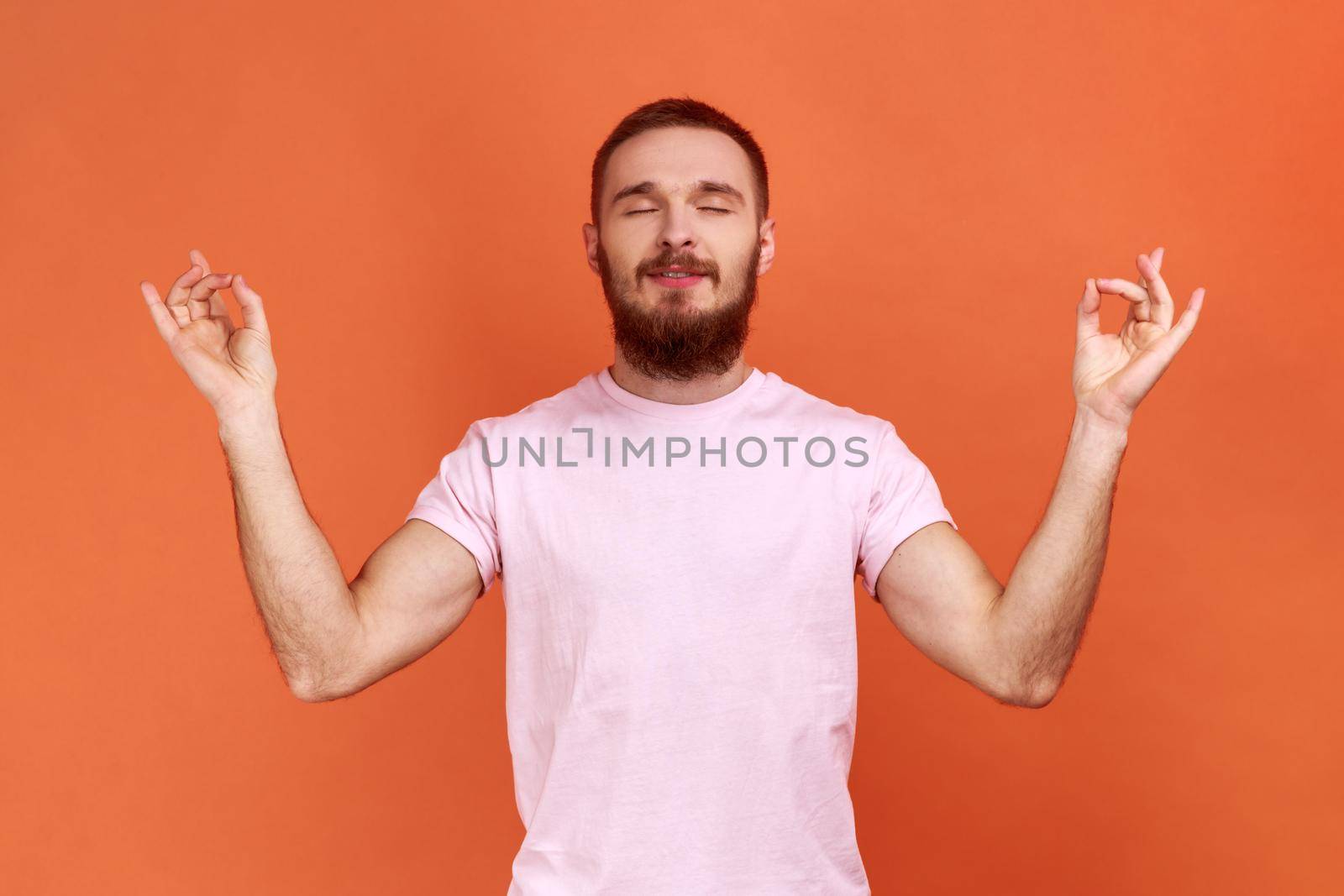 Man standing with raised arms and doing yoga meditating exercise, mudra gesture. by Khosro1