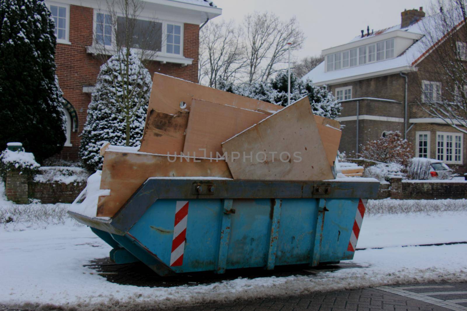 Loaded dumpster near a construction site by studioportosabbia