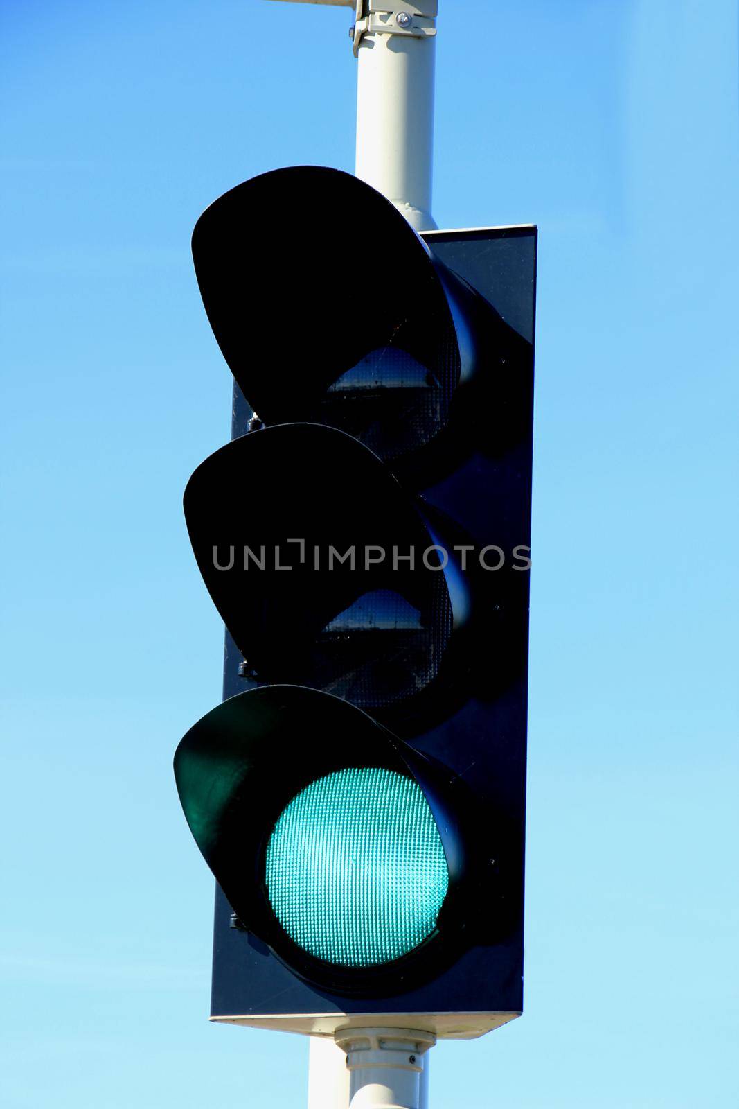 Traffic lights in a clear blue sky by studioportosabbia