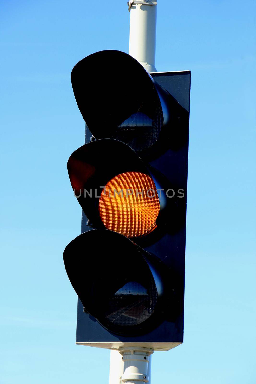 Traffic lights in a clear blue sky by studioportosabbia