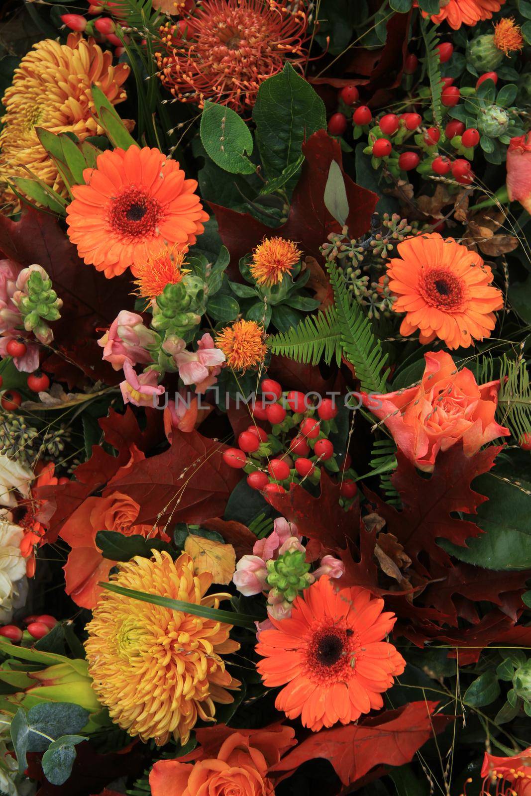 Autumn colored flower arrangement in orange and brown by studioportosabbia