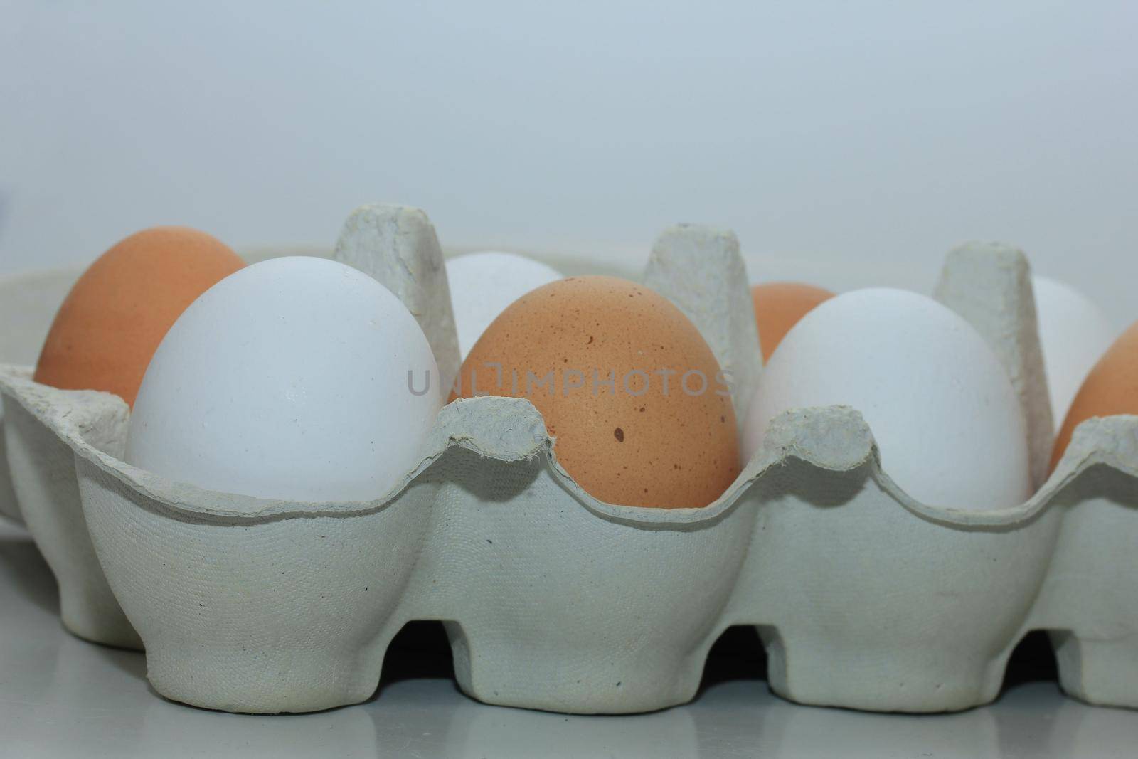 Ten fresh eggs in a carton box by studioportosabbia