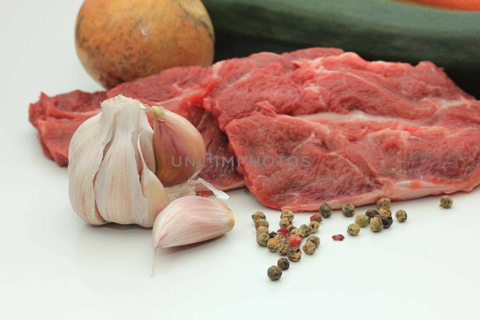 Raw beef, some garlic and mixed pepper by studioportosabbia