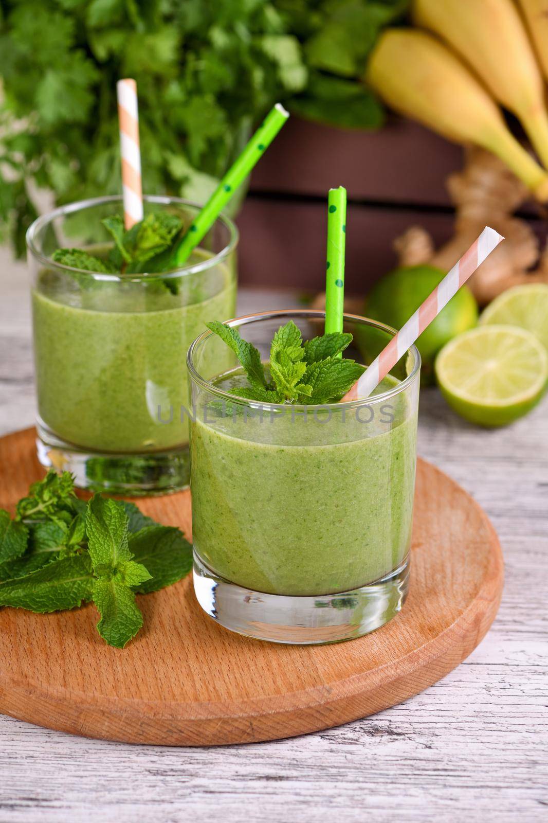 Fresh organic detox green drink smoothie with celery, spinach, banana, cilantro, lime and ginger with refreshing mint. Healthy, dietary, vegetarian food