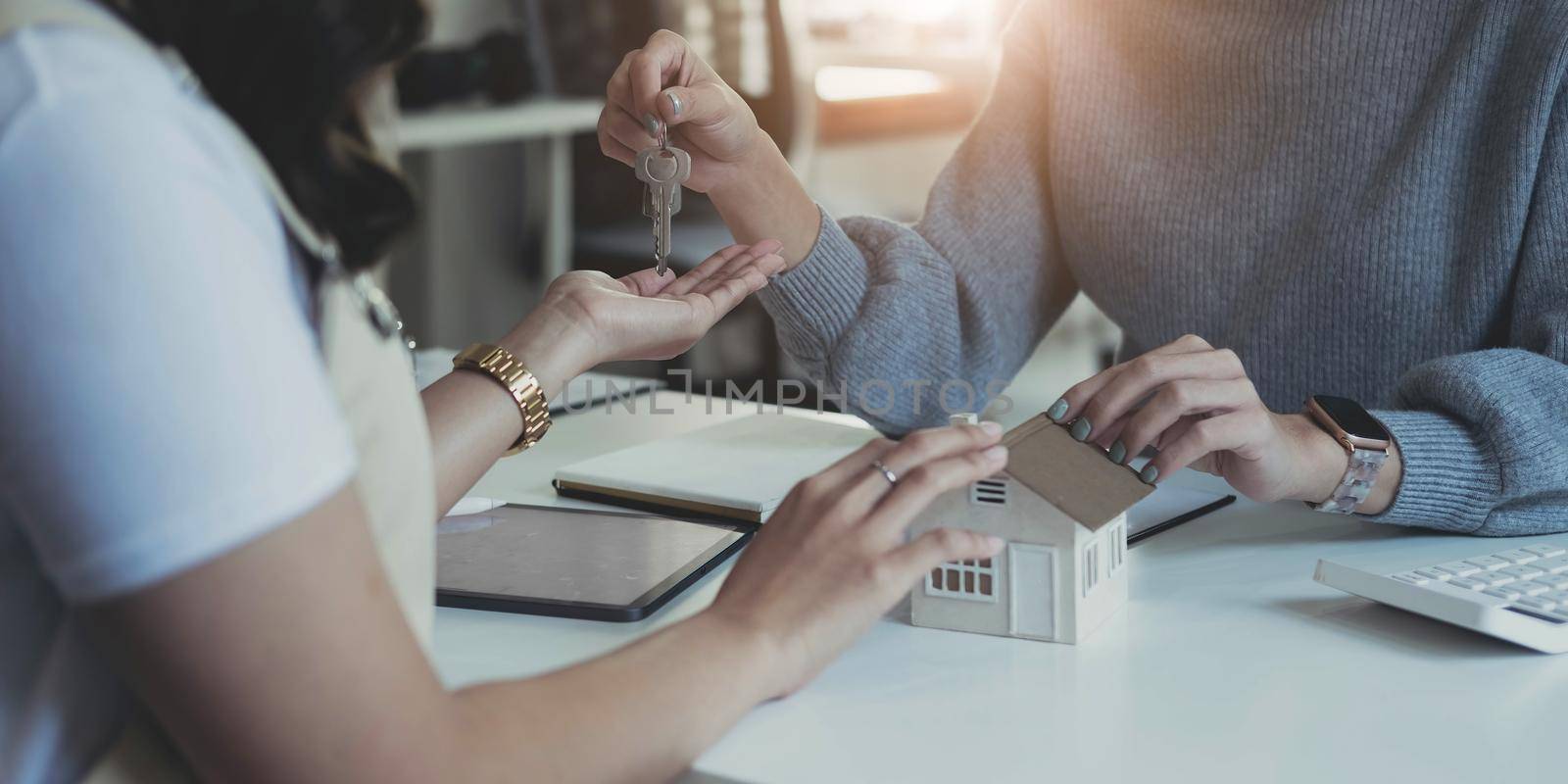 Estate agent giving house keys to client after signing agreement contract real estate with approved mortgage application form, concerning mortgage loan offer for and house insurance..