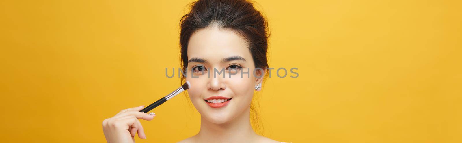 Woman applying make up with brush, isolated. Beauty procedures by makidotvn