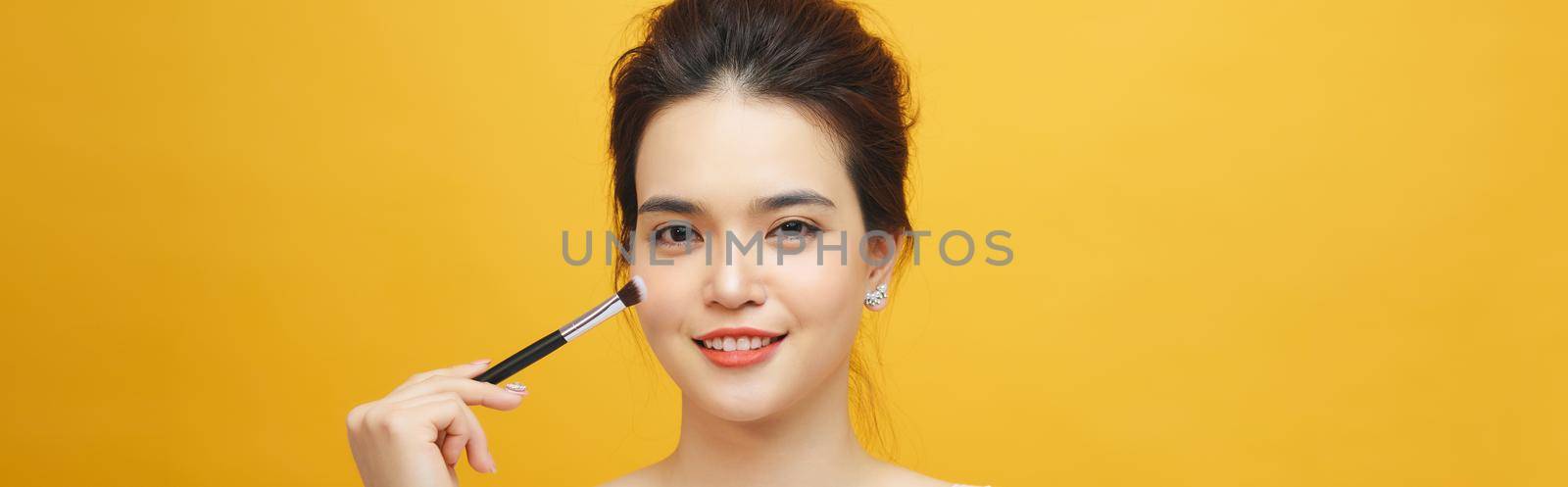 Woman applying make up with brush, isolated. Beauty procedures