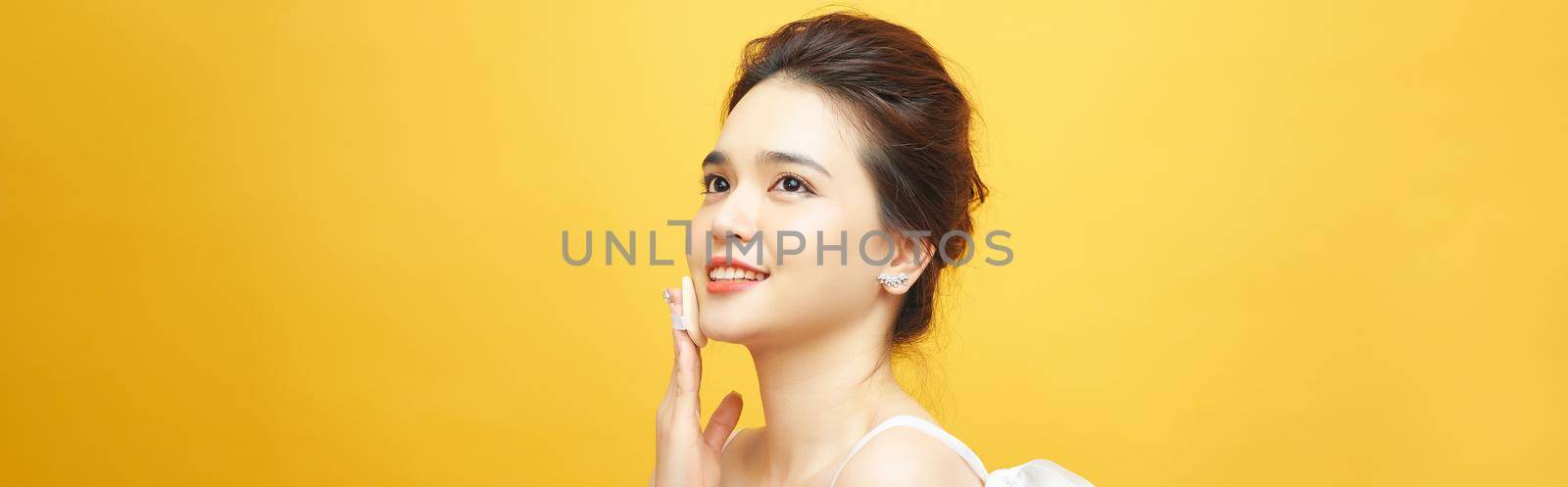 Portrait of asia woman With Cushion Puff And Mirror Applying Makeup Powder Foundation