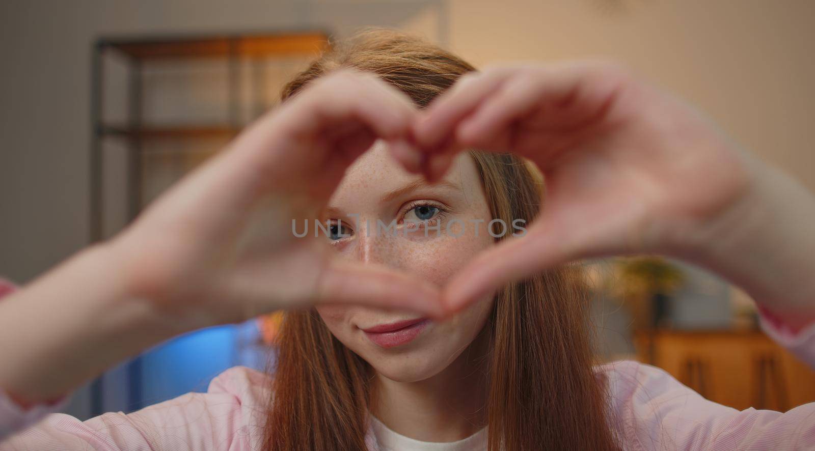 I love you. Teen child girl makes symbol of love, showing heart sign to camera, express romantic feelings, express sincere positive feelings. Charity, gratitude, donation. Children close-up happy face