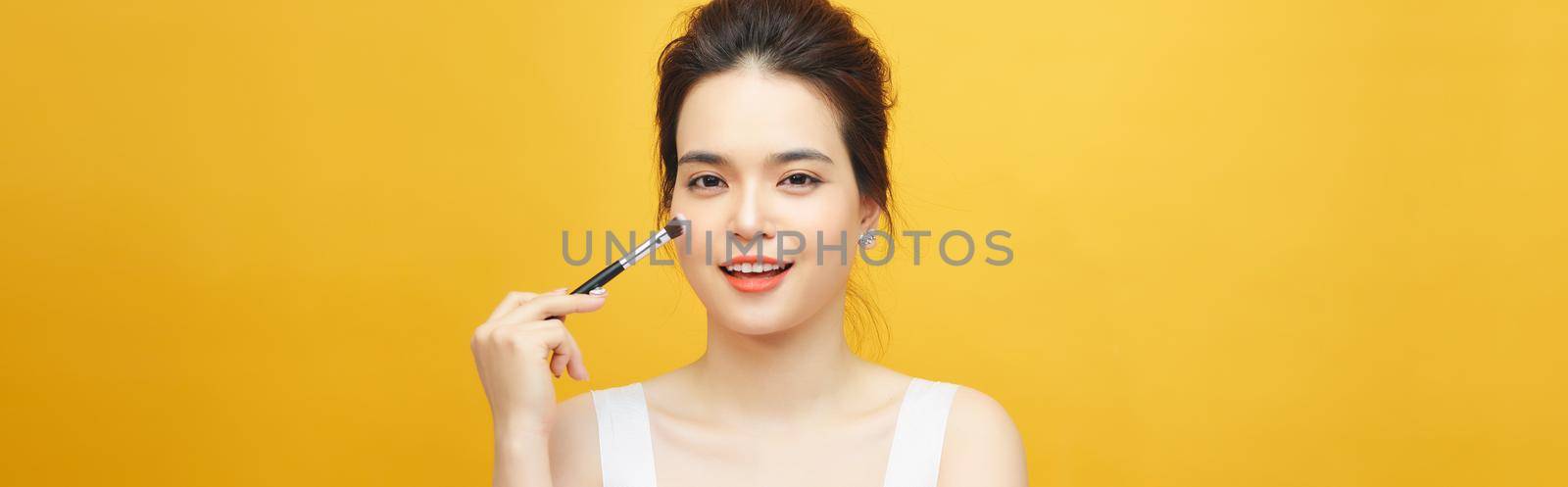 Woman applying make up with brush, isolated. Beauty procedures