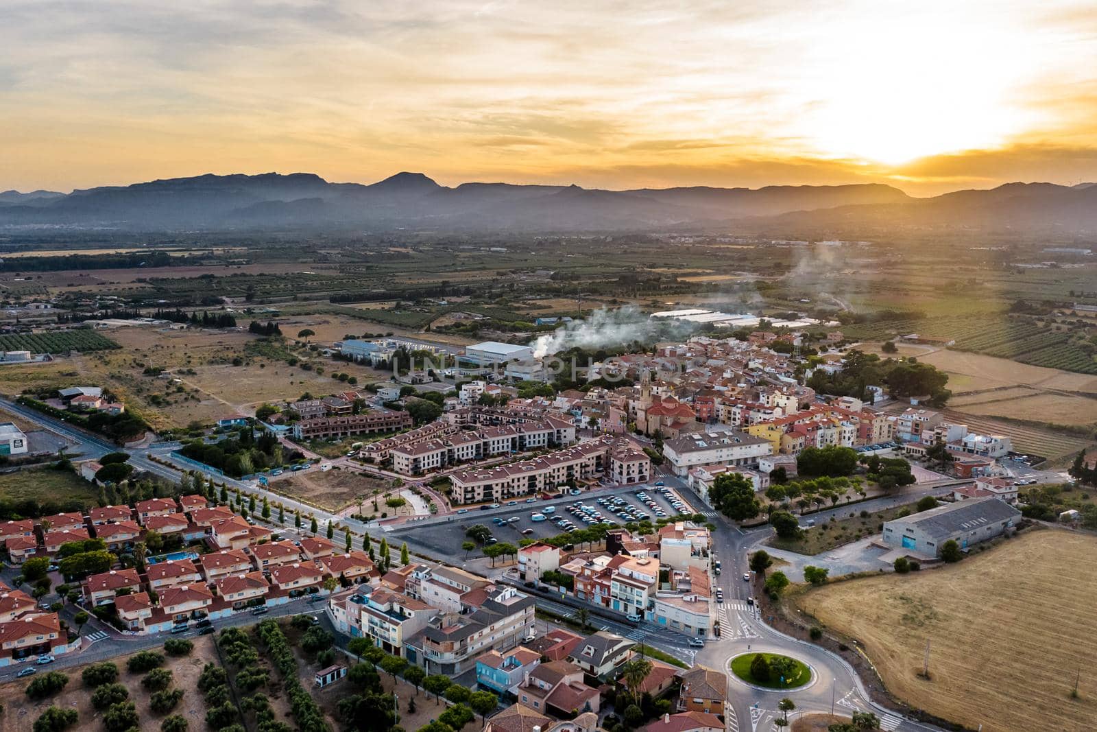 top view of Vinyols i Archs village, Baix Camp, at sunset near of the mountains in Tarragona, next to fields and agriculture industry, aerial view