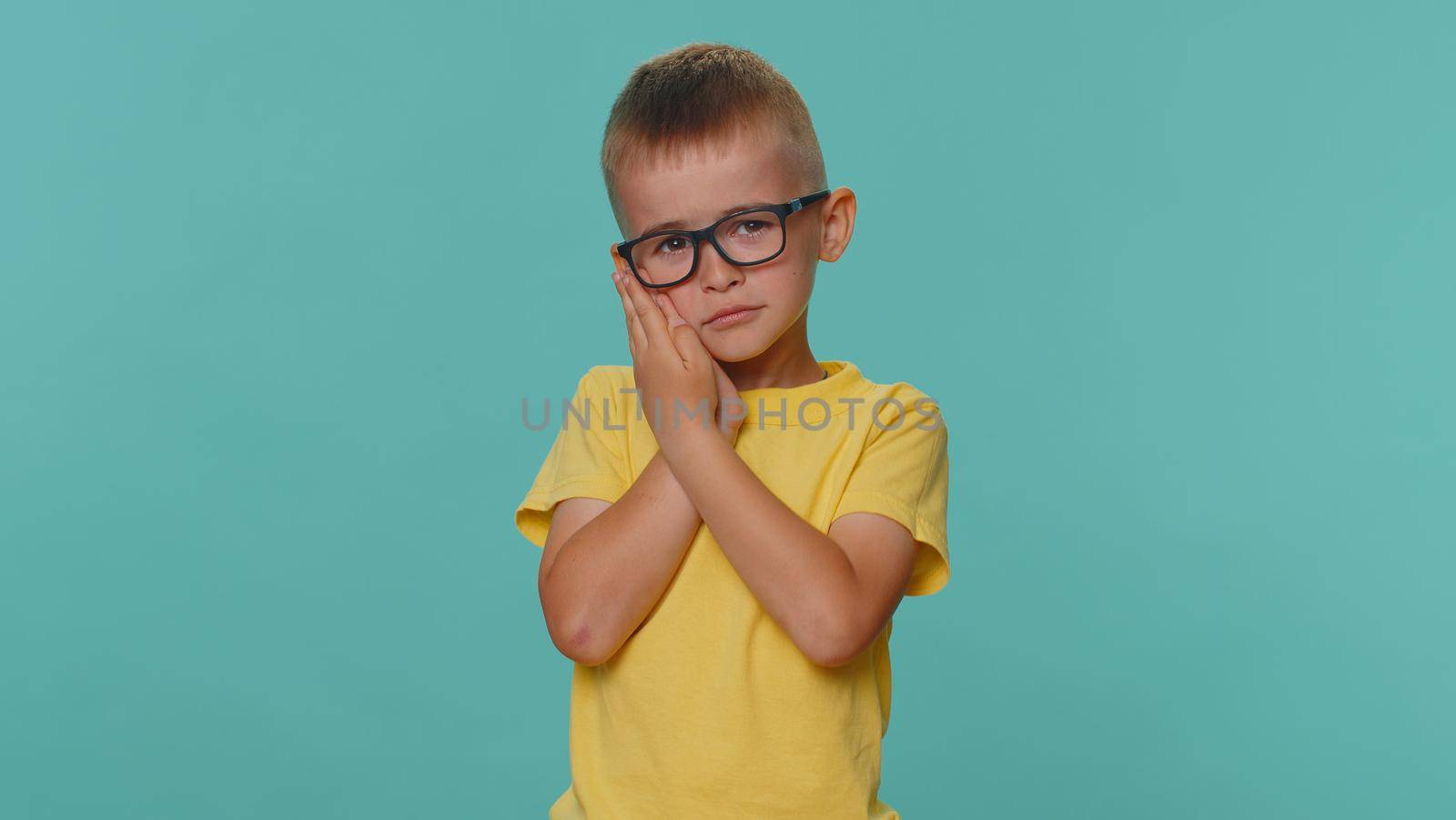 Children boy touching cheek, terrible suffer from painful toothache, sensitive teeth, cavities by efuror