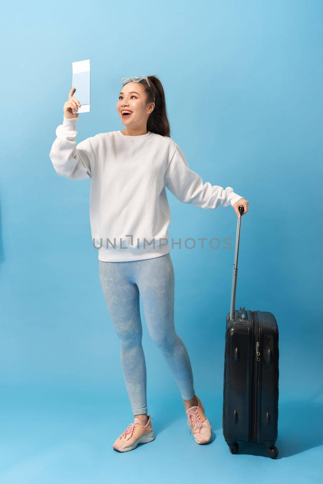 Tourism, summer holidays and vacation concept - Happy woman in casual clothing with travel bag and air ticket over blue background by makidotvn