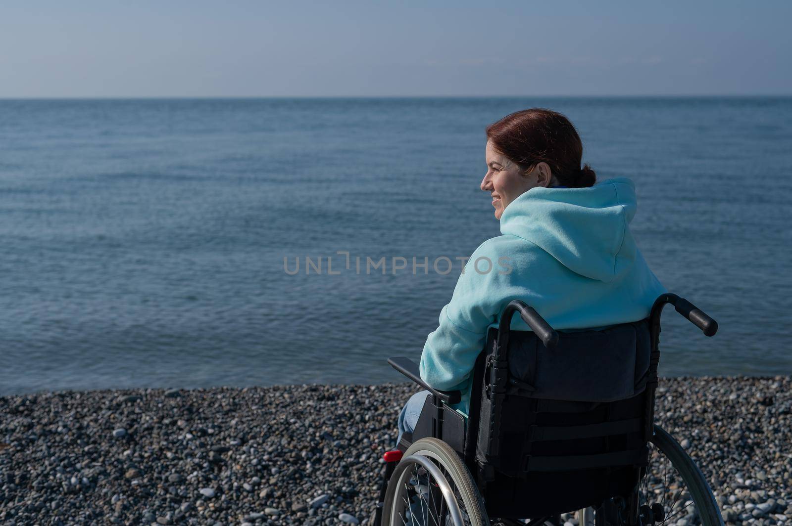 Pacified caucasian woman in a wheelchair on the seashore