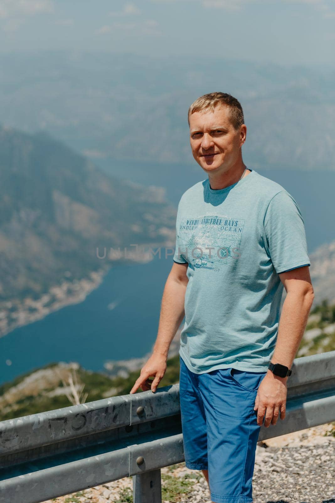 Man tourist enjoys the view of Kotor. Montenegro. Bay of Kotor, Gulf of Kotor, Boka Kotorska and walled old city. Travel to Montenegro concept. Fortifications of Kotor is on UNESCO World Heritage