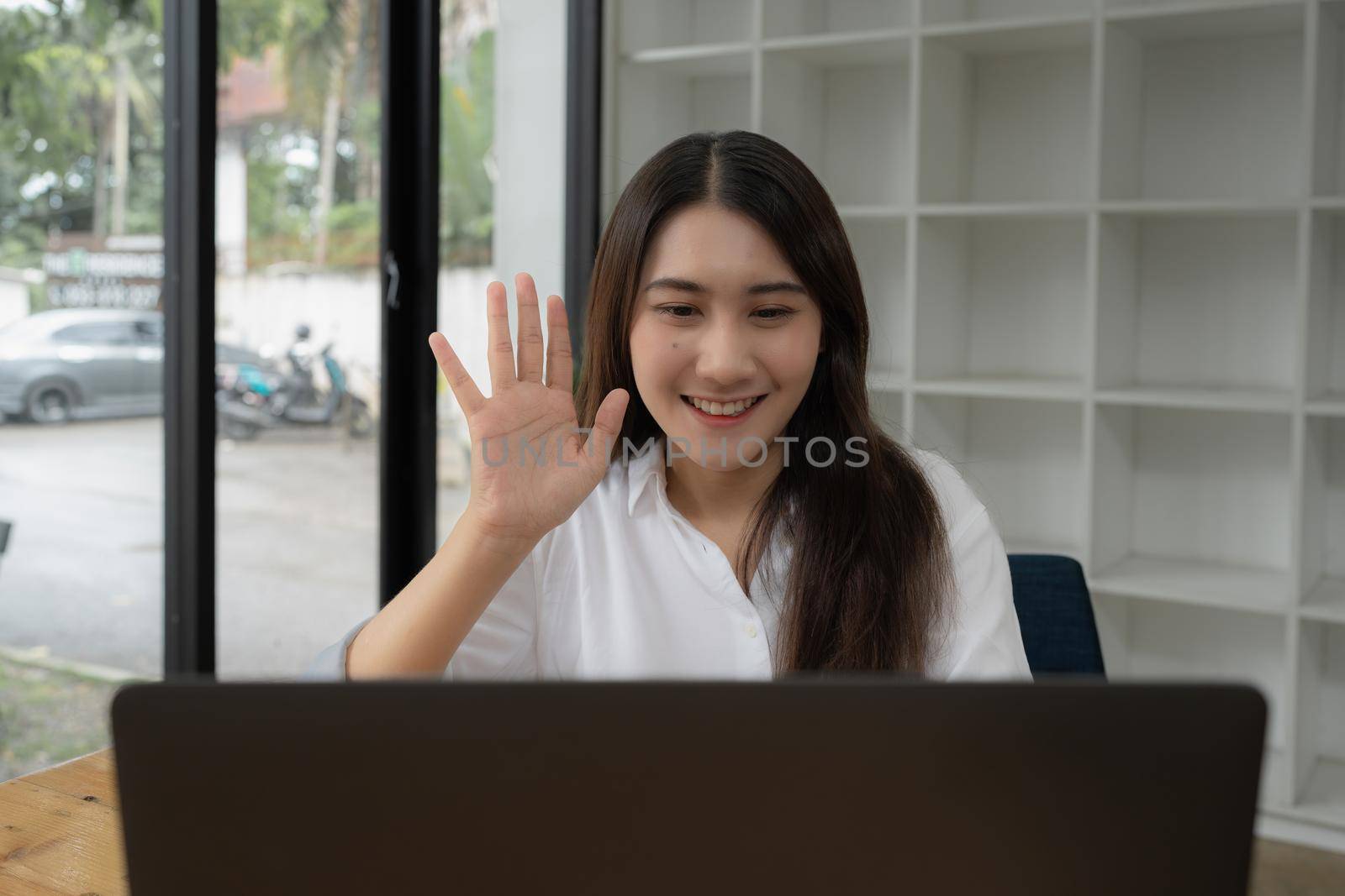 Asian business woman on a video call by laptop. Online meeting concept.