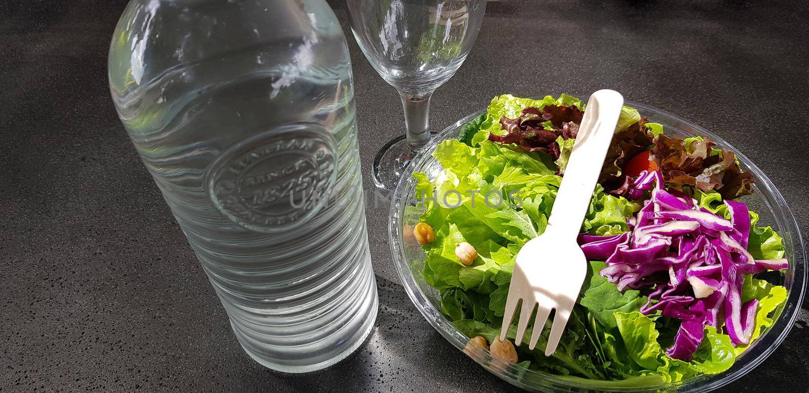 Healthy vegetable salad of fresh tomato, lettuce and red cabbage with wooden spoon and caesar salad dressing Diet menu Top view