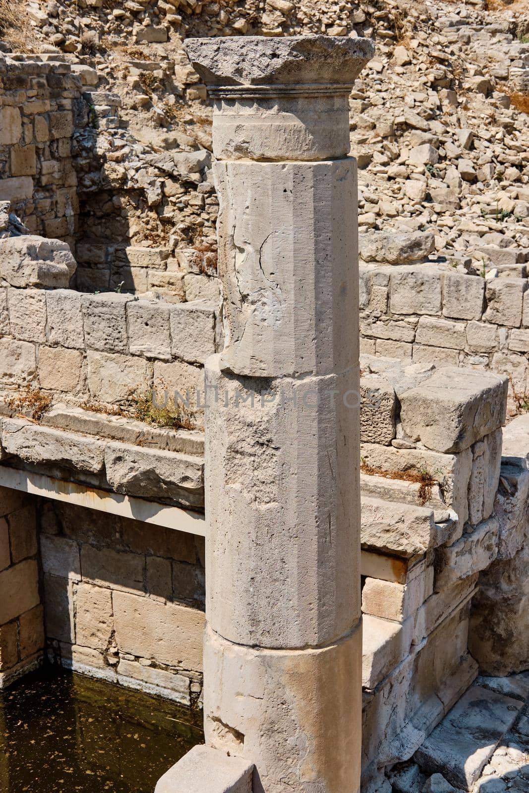 Ancient ruins of the Sanctuary of Apollo Hylates located at the beach of the azure mediterranean sea. Near the Greek town of Kourion. Limassol, Episkopi, Cyprus. Tourism, vacation, traveling, leisure concept.