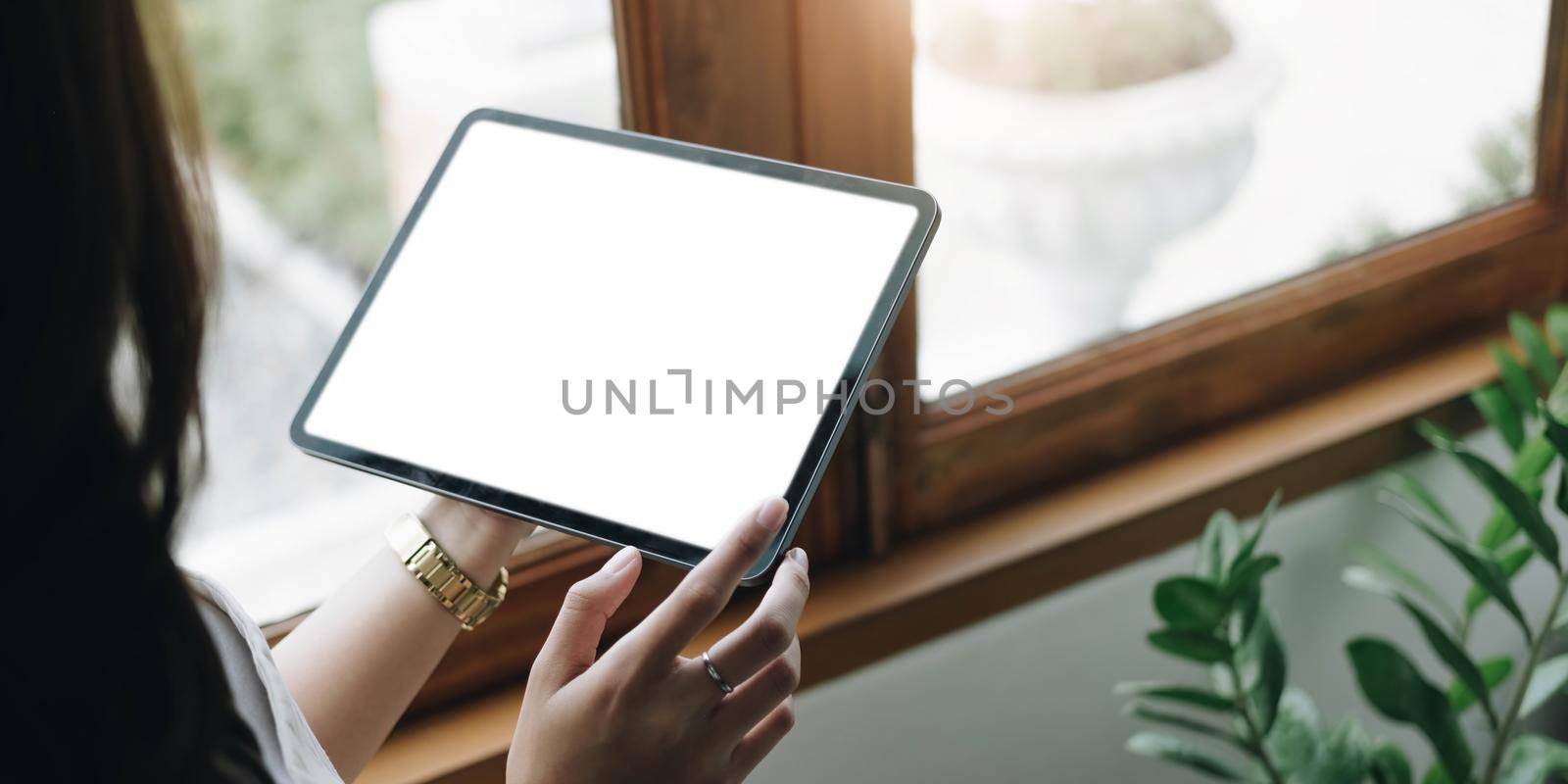 Mockup image of a woman holding digital tablet with blank white desktop screen by wichayada