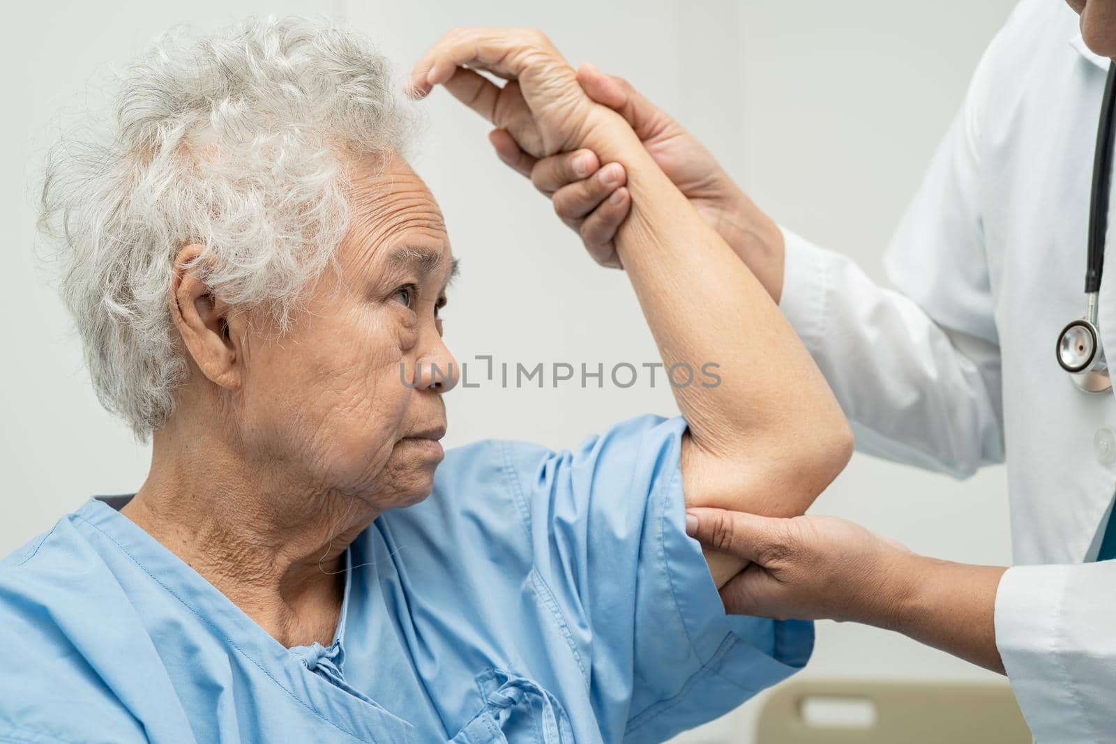 Asian senior or elderly old lady woman patient feel pain her elbow on bed in nursing hospital ward, healthy strong medical concept. by pamai