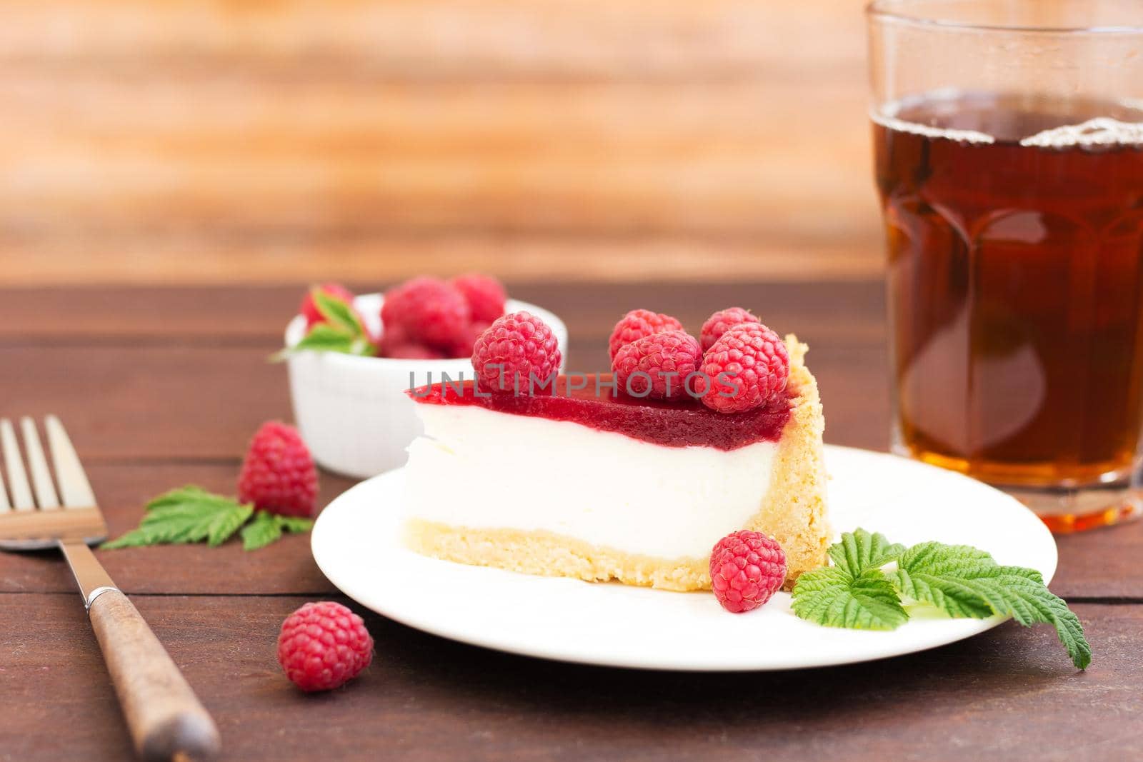 Raspberry pie (cheesecake) made from fresh raspberries with tea on a wooden background. by lara29