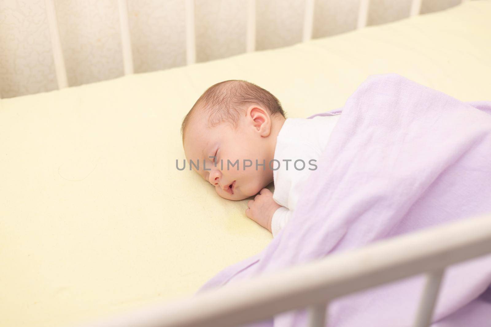 The baby sleeps in the copy space crib . Advertising of children's goods. Illustrating children's articles. A small child. A newborn. A child's dream.