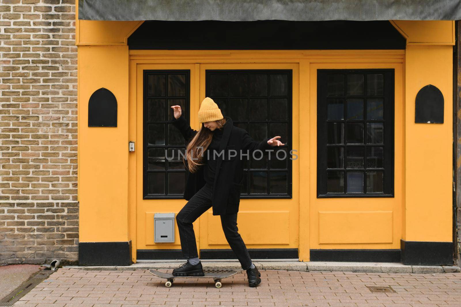 A girl in a yellow hat with a skateboard
