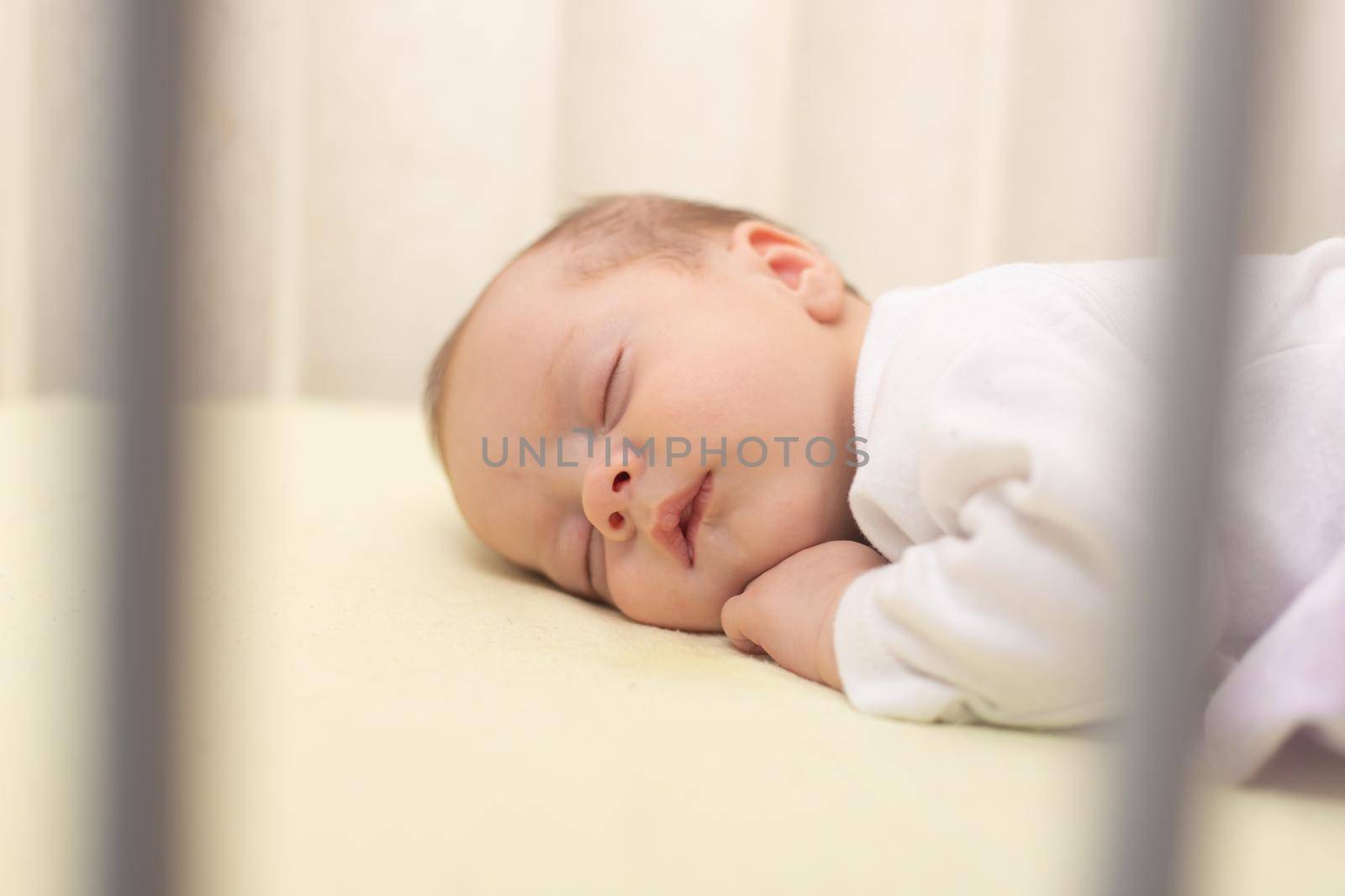 The baby sleeps in the copy space crib . Advertising of children's goods. Illustrating children's articles. A small child. A newborn. A child's dream.