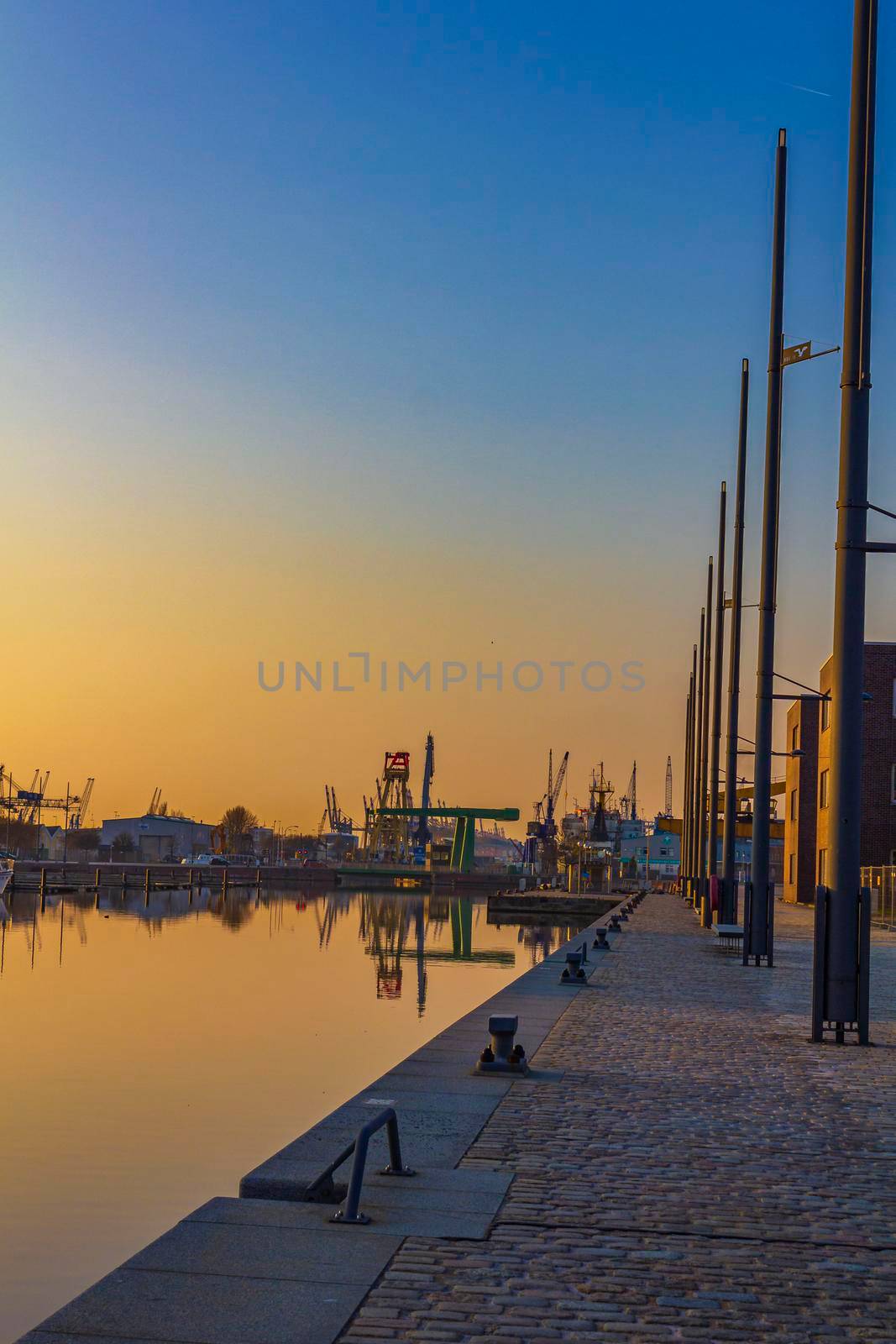 Bremerhaven Germany 12. March 2011 Sunset and cityscape and coast panorama of ATLANTIC Hotel Sail City lighthouse architecture ships yachts boats dike and landscape of Bremerhaven in Germany.