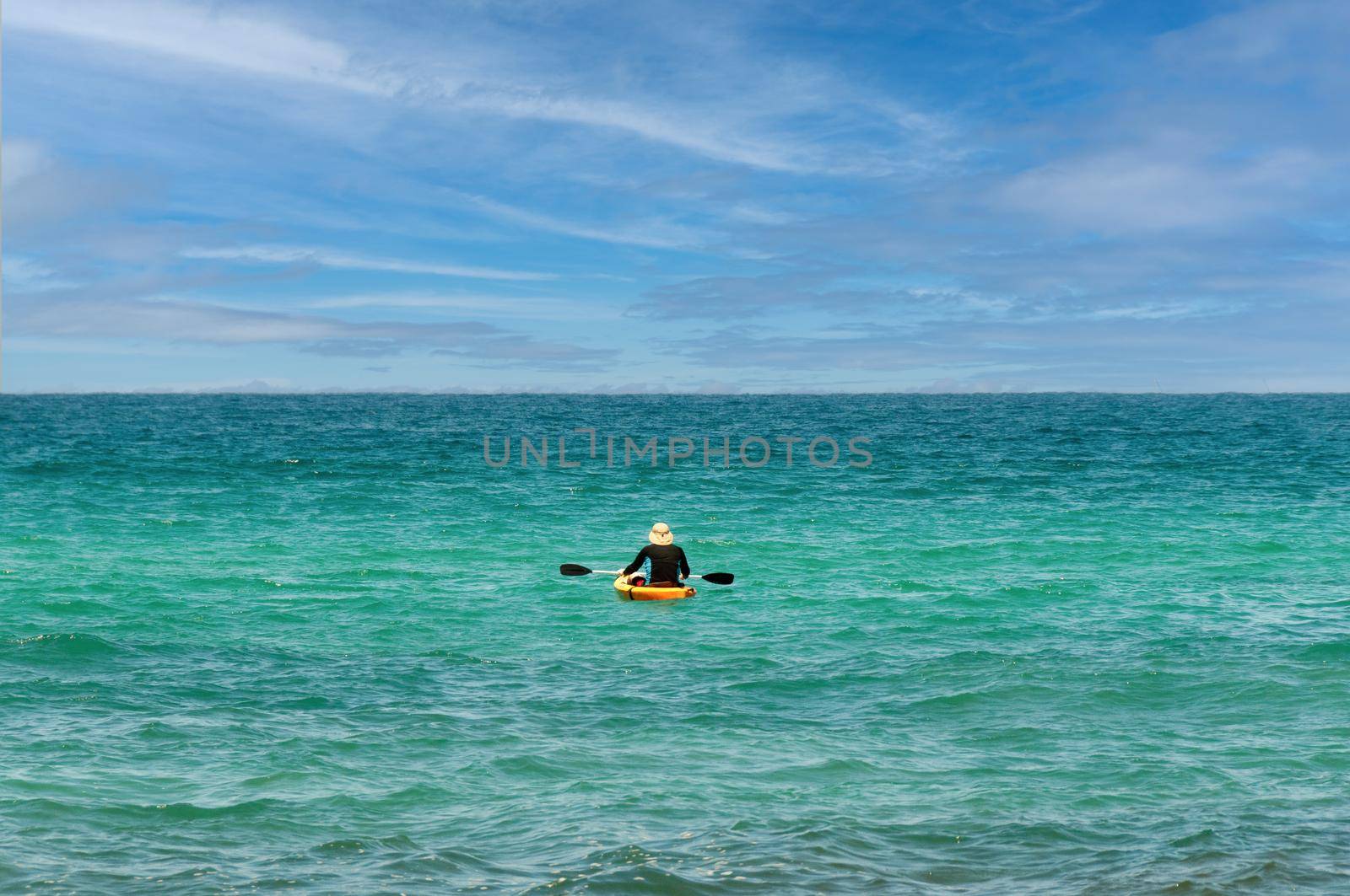 The guy sailed on a kayak into the open sea and sits in a kayak enjoying the scenery