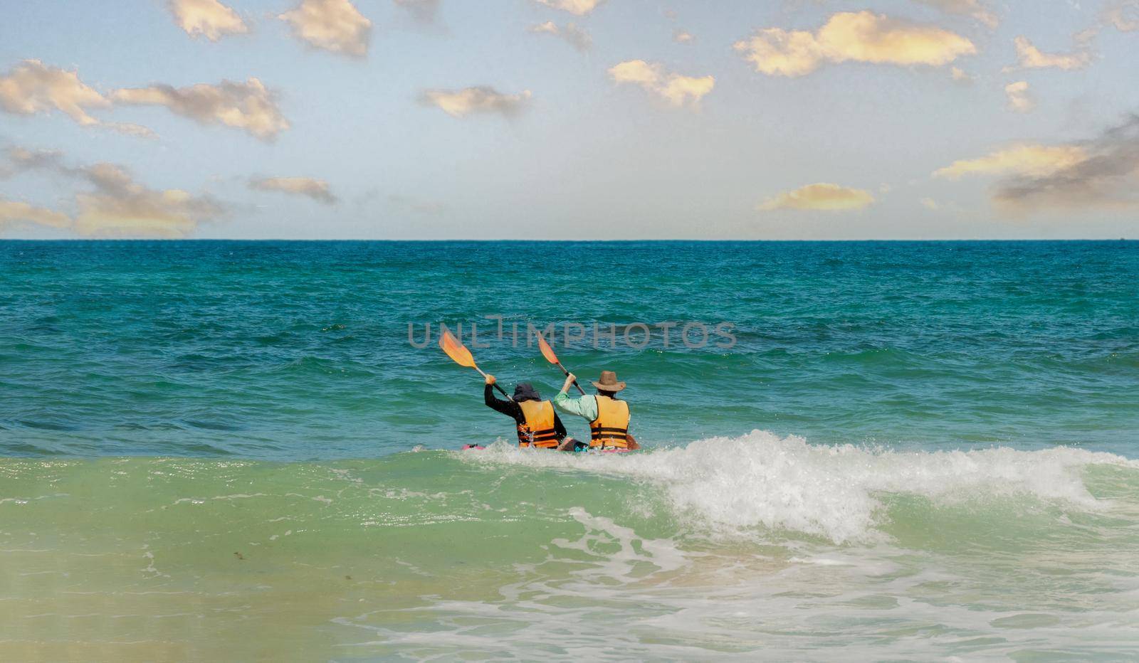 Two fellow kayakers went out in the evening to swim in a kayak in the sea