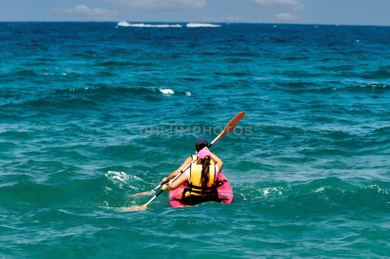 A guy and a girl are kayaking in the open sea by ben44