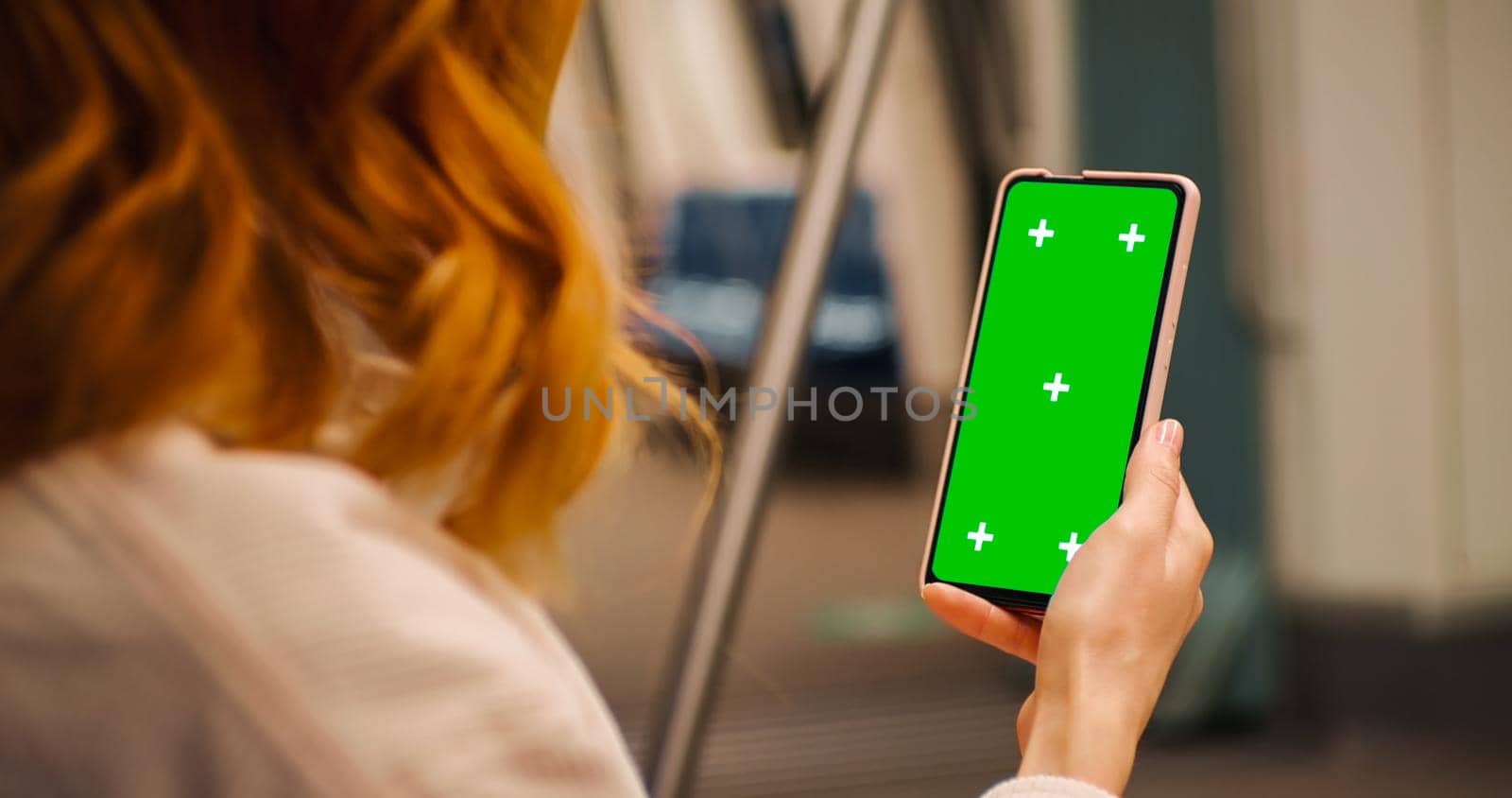 Woman hands on green screen phone watching news on a train. Technology in the underground. Ignorance in public places. Copyspace phone. Green Screen Mock Up Display.