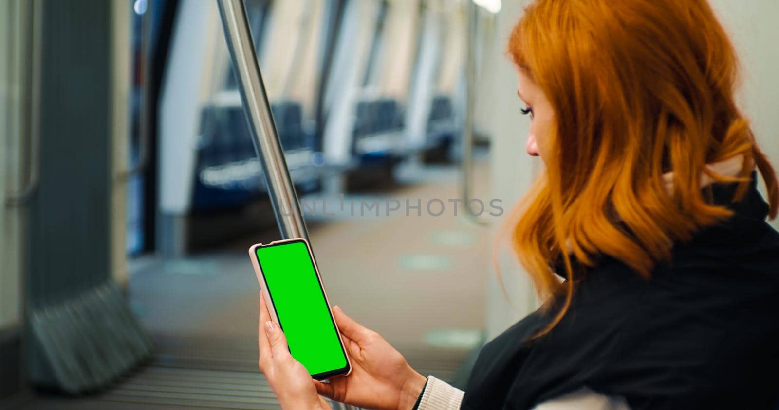 Side View of Woman Holding and watching Green Screen Phone in the Train. by RecCameraStock