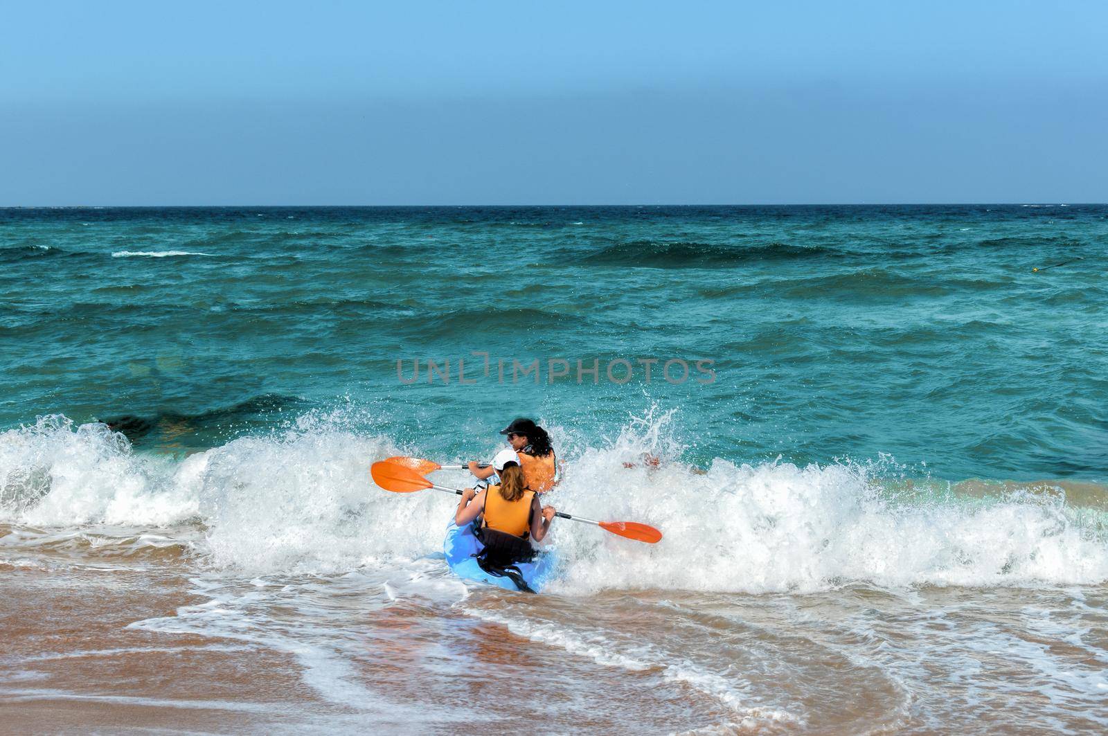 Two girls are trying to swim out of the oncoming wave by ben44