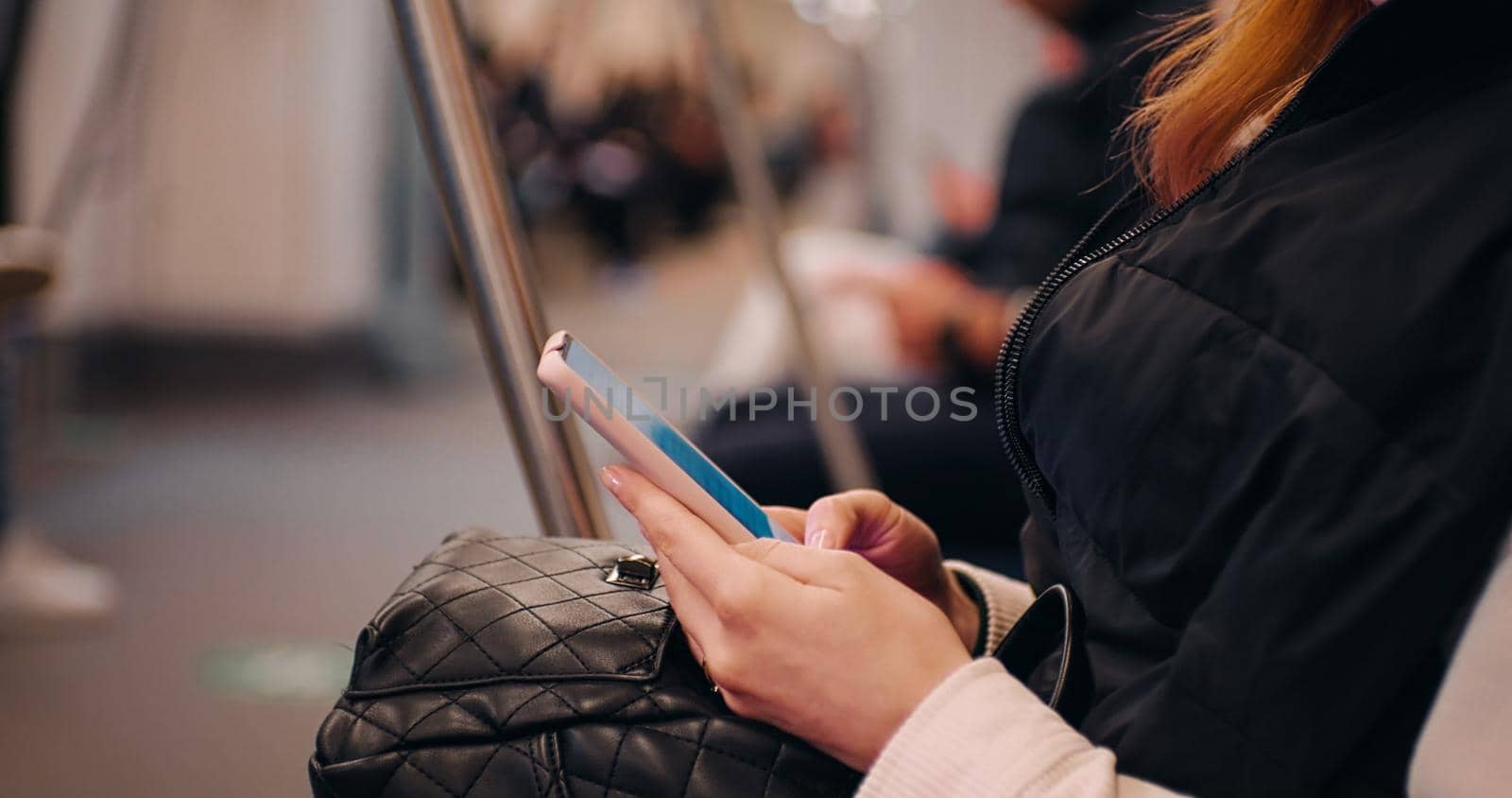 Side view of woman surfing online on smartphone in public transport. Female hands applying for job online. Technology opportunities nowadays.