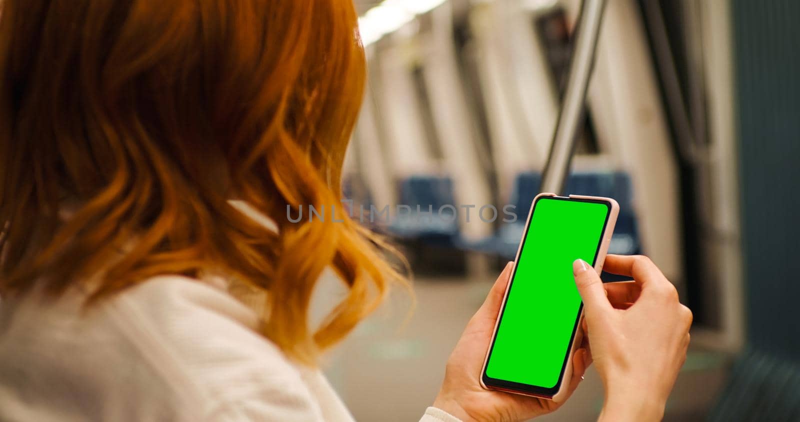 Female using phone for one advertisement on metro city transport. Student exchanging route transport scrolling on green screen cellphone.