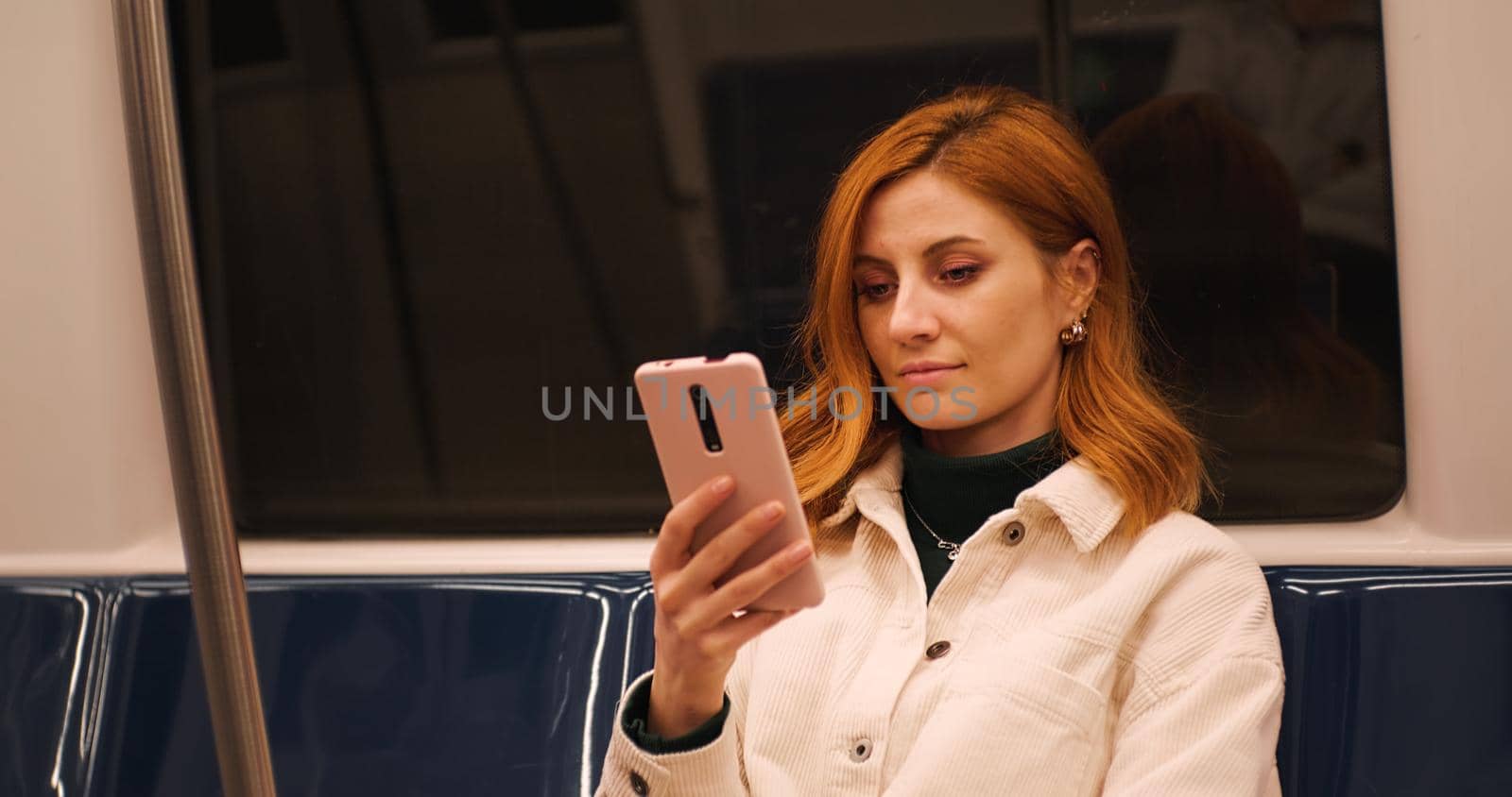 Woman on train using smartphone scrolling. by RecCameraStock