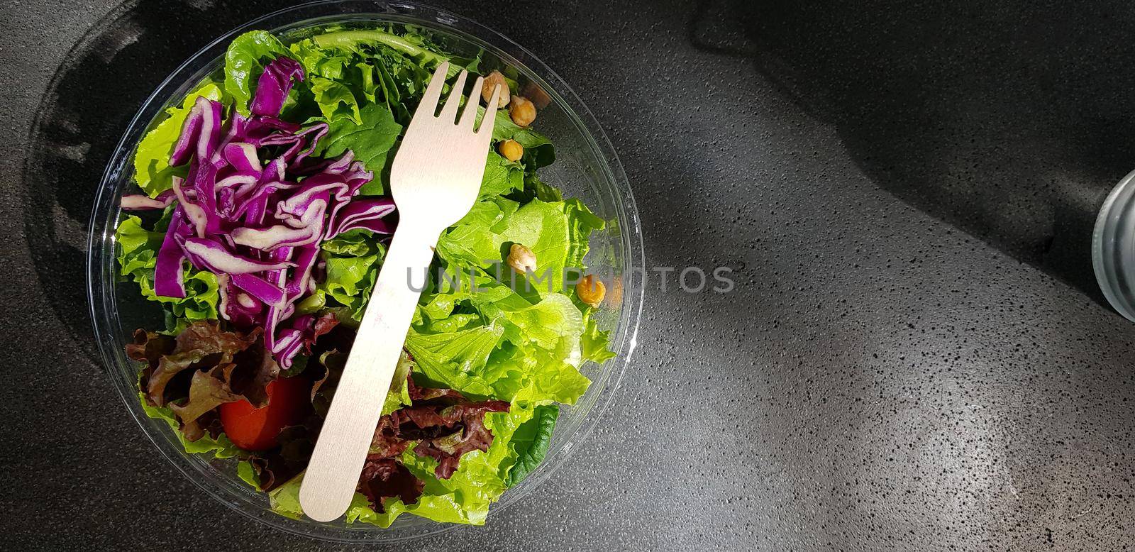 Healthy vegetable salad of fresh tomato, lettuce and red cabbage with wooden spoon and caesar salad dressing Diet menu Top view