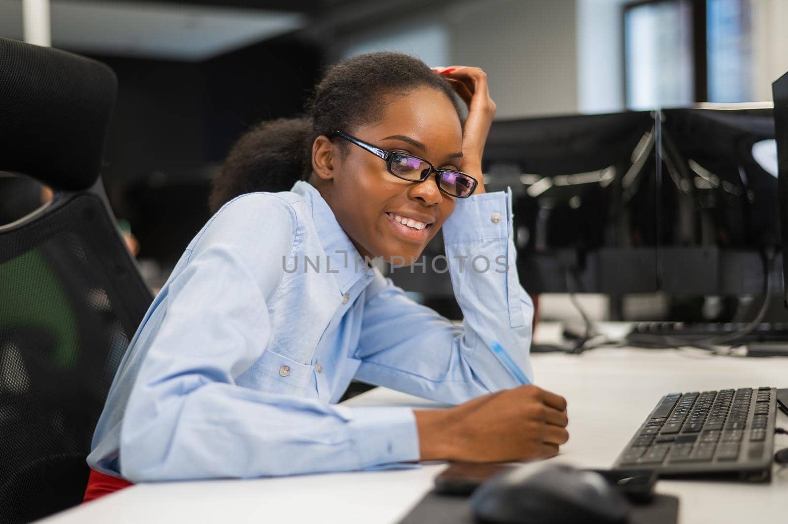 African young woman typing on a computer at her desk in the office. by mrwed54